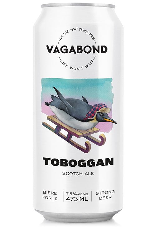 Canette de bière Vagabond Toboggan – Scotch Ale forte à 7,5%, illustrée d’un pingouin sur une luge avec tuque, bière artisanale hivernale riche et maltée