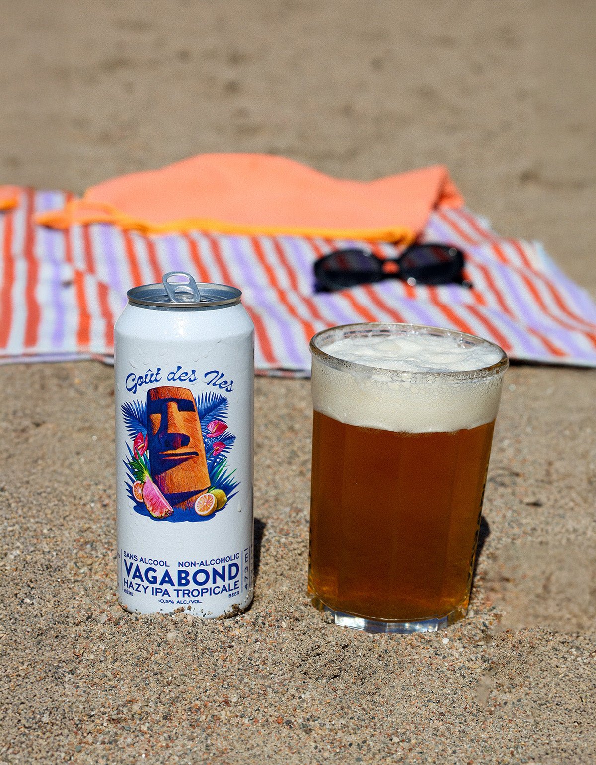 Gout des Iles Bieres Vagabond biere sans alcool Hazy IPA tropicale canette 473ml avec bière sur une plage.